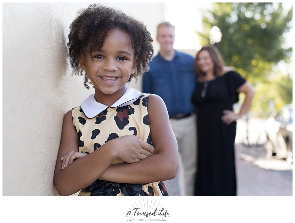 A Focused Life Photography Marietta Square Family Photographer Girl in Leopard Dress with parents behind