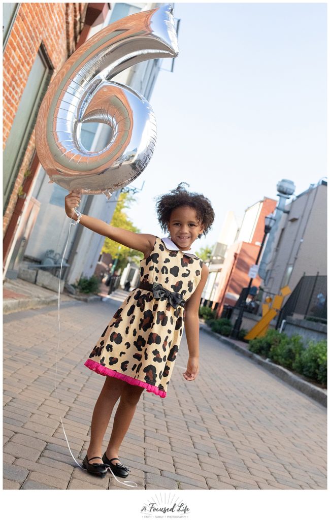 A Focused Life Photography Marietta Square Family Photographer Girl in Leopard Dress holding birthday balloon