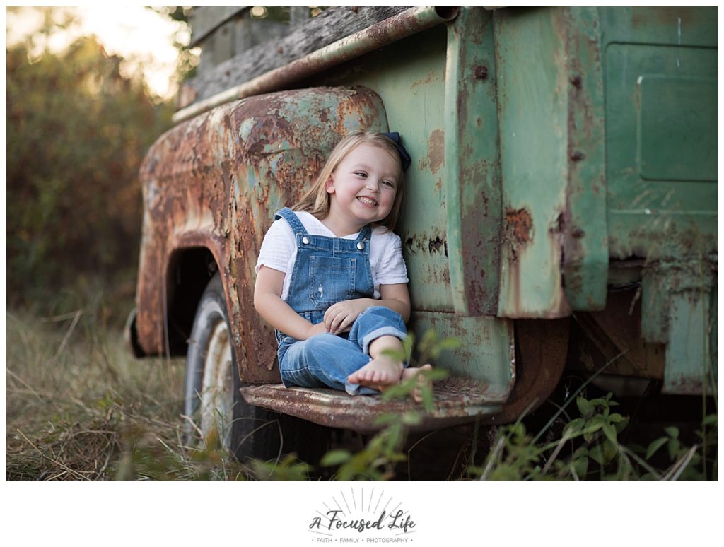 4 year old posing with old truck at Vaughters Barn at Arabia Mountain by A Focused Life Photography