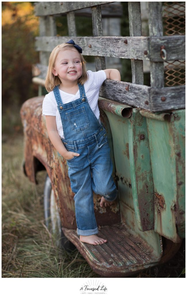 4 year old posing with old truck at Vaughters Barn at Arabia Mountain by family and children photographer A Focused Life Photography