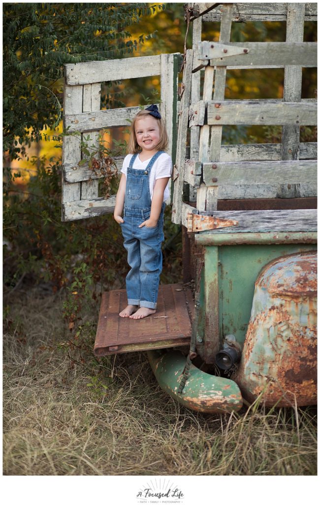 4 year old posing with old truck at Vaughters Barn at Arabia Mountain by A Focused Life Photography