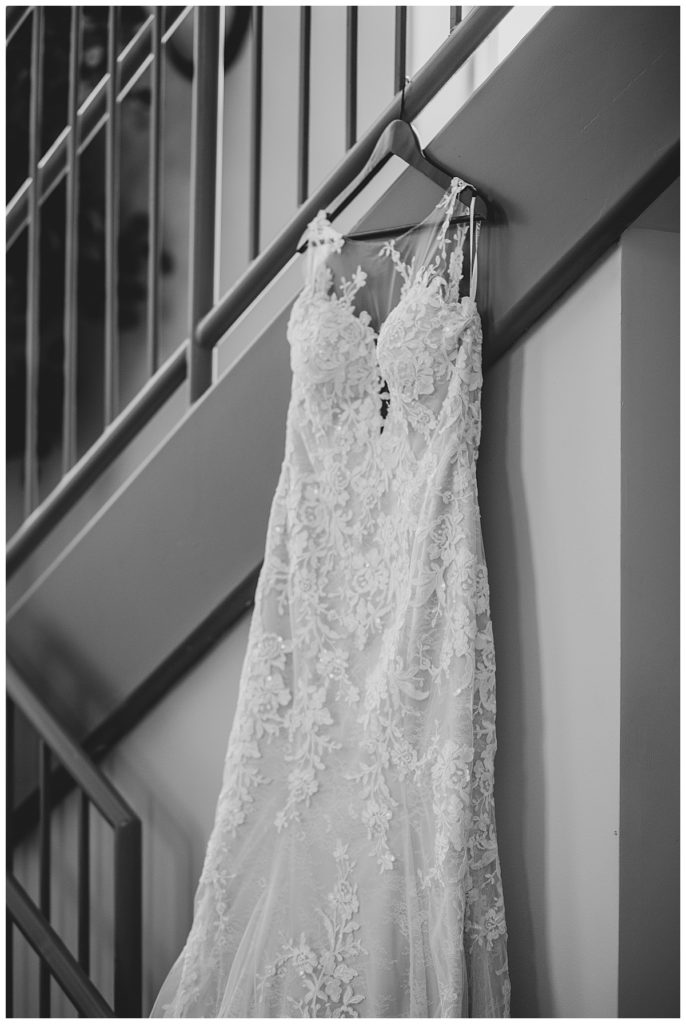 Black and white of bride's dress hanging in church