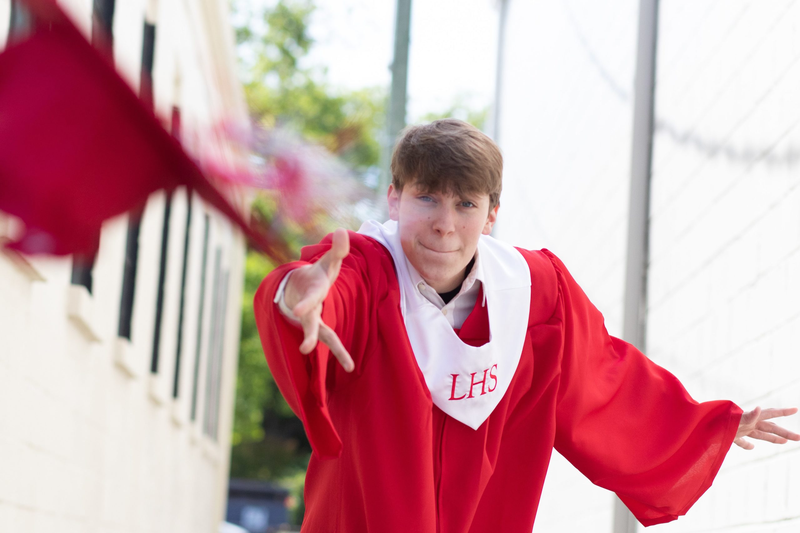 High School Senior throwing his cap at the camera. Photography by A Focused Life Photography in Monroe, GA.