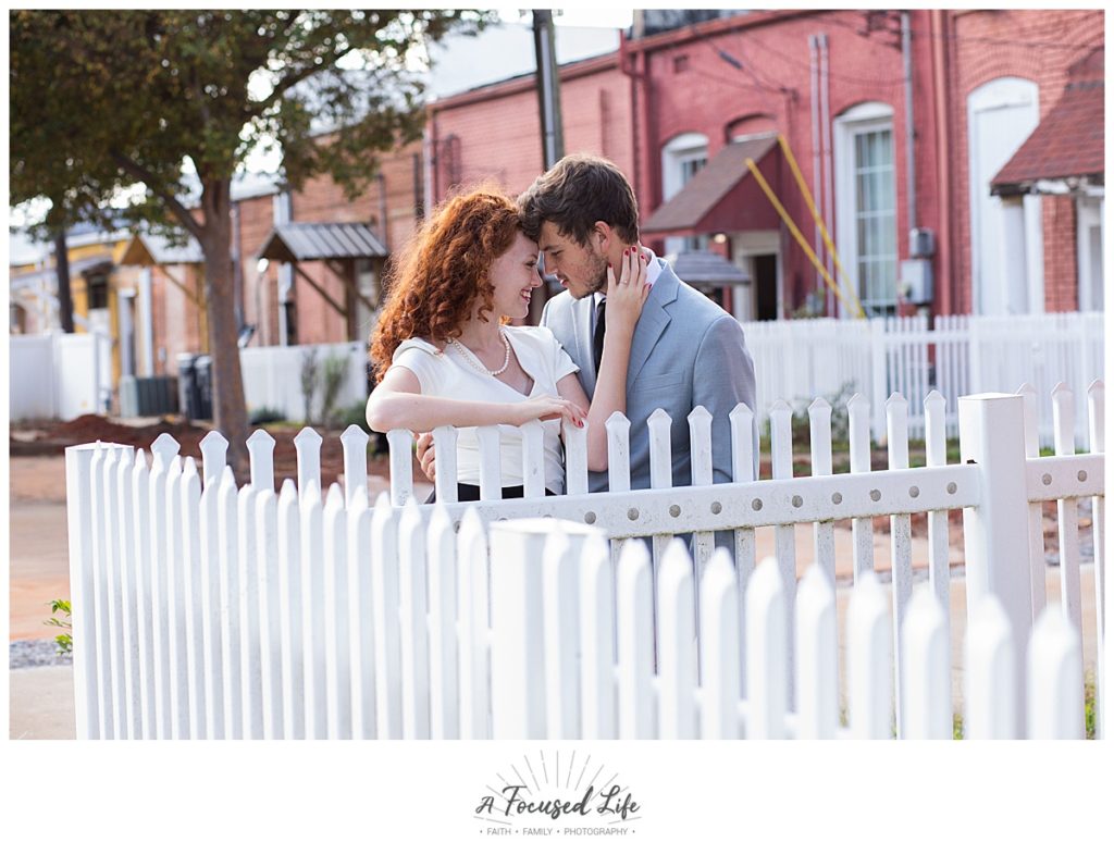 Couple posing on picket fence