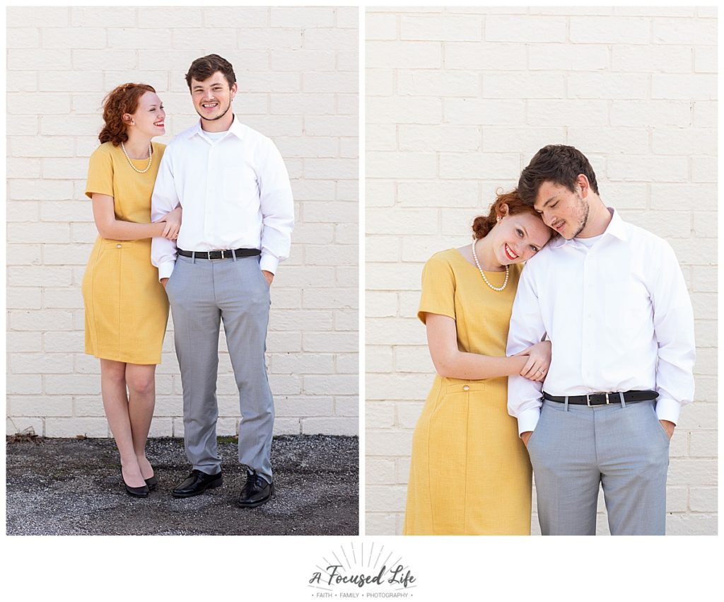 Red head girl wearing mustard yellow dress in engagement session against white brick wall
